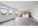 Open living space with large windows, a sliding door, and an island kitchen with stainless steel appliances at 4115 Marble Dr, Mead, CO 80504