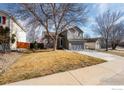 Charming two-story home with gray siding, brick accents, and a well-maintained front lawn at 5411 E 128Th Dr, Thornton, CO 80241