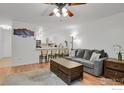 Inviting living room with light wood floors, ceiling fan, and open to kitchen at 665 S Alton Way # 12A, Denver, CO 80247