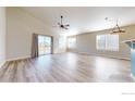 Bright living room featuring hardwood floors, large windows, and modern lighting at 692 Biscayne Ct, Berthoud, CO 80513