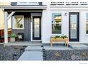 Close-up of the home's entrance with a modern black door and stylish landscaping at 841 Hearteye Trl, Lafayette, CO 80026