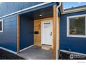 Close-up of entrance featuring a white door and natural wood accents at 895 Oswego St, Aurora, CO 80010