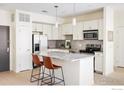 Modern kitchen featuring a granite island with seating and stainless steel appliances in an open-concept design at 13456 Via Varra # 119, Broomfield, CO 80020