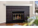 Close-up view of the fireplace featuring unique tile and a cozy, inviting fire at 1470 S Quebec Way # 234, Denver, CO 80231