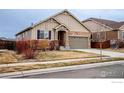 Inviting single-Gathering home featuring stone accents, a two-car garage, and a well-maintained front yard at 17012 Lipan St, Broomfield, CO 80023