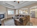 Open-concept living space featuring a comfortable sectional, fireplace, and seamless access to the kitchen at 17012 Lipan St, Broomfield, CO 80023