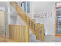 Bright foyer featuring an open staircase with natural wood railings at 2011 100 Year Party Ct # 2, Longmont, CO 80504