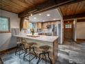 Open kitchen with a marble counter, stainless steel appliances, and rustic stools at the breakfast bar at 208 Wild Tiger Rd, Boulder, CO 80302