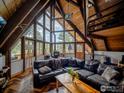 Cozy living room with a wood-burning stove, vaulted ceilings, and floor to ceiling windows at 208 Wild Tiger Rd, Boulder, CO 80302