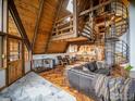 Spacious living room featuring a spiral staircase, hardwood floors, and a rustic, wood-paneled ceiling at 208 Wild Tiger Rd, Boulder, CO 80302