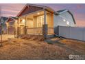 Charming front porch perfect for relaxing with a well-manicured lawn and stone accents at 2161 Cadman St, Berthoud, CO 80513