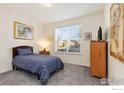 Cozy bedroom featuring a plush bed, neutral walls and a sunlit window at 2342 Spotswood St, Longmont, CO 80504