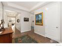 Inviting hallway with hardwood floors and recessed lighting, showcasing an art display at 2342 Spotswood St, Longmont, CO 80504