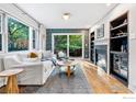 Cozy living room with a fireplace, built-in shelves, large window, and sliding glass door to the yard at 2625 6Th St, Boulder, CO 80304