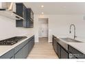 Beautiful kitchen featuring gray cabinets, an island with a stainless steel sink, and modern appliances at 3013 South Flat Cir, Longmont, CO 80503