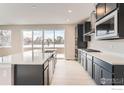 This kitchen features a stainless steel hood, gray cabinets, and a sink that faces a large window at 3013 South Flat Cir, Longmont, CO 80503