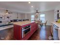 Open kitchen with hardwood floors, an island, seating and stainless steel appliances at 339 S Hoover Ave, Louisville, CO 80027