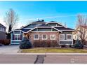 Charming exterior view showcasing a two-story home with stone accents and well-manicured landscaping at 4211 Riley Dr, Longmont, CO 80503