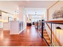 Inviting foyer featuring hardwood floors, staircase, and open view to the kitchen and living room at 4211 Riley Dr, Longmont, CO 80503