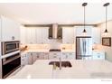 Modern kitchen with white cabinets, stainless steel appliances, and a large center island at 4211 Riley Dr, Longmont, CO 80503