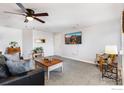 Cozy living room with carpet, a ceiling fan, and a mounted TV at 5425 County Road 32 # 27, Mead, CO 80504