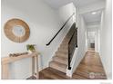 Bright foyer with wood floors, staircase, and modern decor at 5678 W 10Th Pl, Lakewood, CO 80214