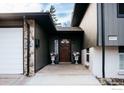 Inviting entryway with stone accents, a welcoming wooden door, and elegant planters at 6833 S Buffalo St, Littleton, CO 80120