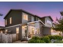 Side view of a two-story home with stone accents, a welcoming porch, and a well-maintained front yard at 6894 E 133Rd Pl, Thornton, CO 80602