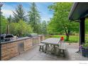 Outdoor kitchen with stainless steel grill, pizza oven, sink, stone counter, and picnic table at 835 Linden Ave, Boulder, CO 80304