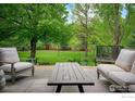 Outdoor seating area with comfortable chairs and a coffee table overlooking the landscaped backyard at 835 Linden Ave, Boulder, CO 80304