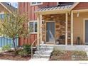 Charming front entrance with stone accents, covered porch and manicured landscaping at 1317 Country Ct # B, Longmont, CO 80501