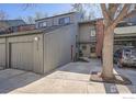 Contemporary townhouse with gray siding, brick accents, and two-car garage with a tree in the front yard at 1513 48Th St, Boulder, CO 80303