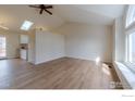 Bright living room showcasing wood floors, modern ceiling fan, and natural light from a skylight at 1624 Foster Dr, Longmont, CO 80501