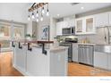 Modern kitchen featuring stainless steel appliances, white cabinetry, and a large island with a wooden bar top at 1630 N Clarkson St # 110, Denver, CO 80218