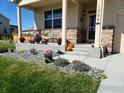 Inviting front porch adorned with seasonal flowers and plants, enhancing curb appeal and charm at 1799 Jade Ave, Brighton, CO 80603