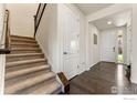 Inviting foyer with hardwood floors, a staircase, and views into adjacent rooms at 2310 Provenance St, Longmont, CO 80504