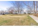 Exterior view of townhomes with a spacious green lawn and walkways at 300 Owl Dr, Louisville, CO 80027