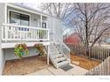 Inviting entrance with a white railed porch, hanging flower baskets, and landscaped surroundings at 300 Owl Dr, Louisville, CO 80027