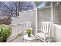 Cozy porch featuring white rocking chairs, a small table with flowers, and a view at 300 Owl Dr, Louisville, CO 80027