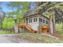 Charming exterior cabin view features wood porch, lots of windows and included dog house at 30690 Highway 72, Golden, CO 80403