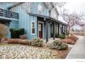 Townhome with a covered front porch and a small balcony, surrounded by mature landscaping and snow at 3671 Pinedale St # G, Boulder, CO 80301