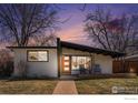 Beautiful exterior of a single-story home with a well-manicured front lawn and a cozy front porch with seating at 4970 Hooker St, Denver, CO 80221