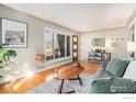 Cozy living room featuring hardwood floors, exposed brick accents, ample natural light, and stylish furnishings at 4970 Hooker St, Denver, CO 80221