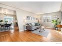 Bright living room with hardwood floors, large windows, comfortable seating, and an open floor plan to dining area at 4970 Hooker St, Denver, CO 80221