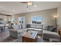 Bright living room featuring a large sectional sofa, plush carpet, and plenty of natural light at 655 Lene Ln, Berthoud, CO 80513