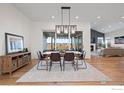 Bright dining room with modern lighting, hardwood floors, and sliding glass doors to outdoor living area at 751 Green Mountain Dr, Erie, CO 80516