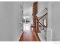Hallway with hardwood floors and stairs that lead to a bright living space with a fireplace at 10895 W Half Moon Pass, Littleton, CO 80127