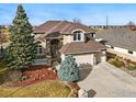 Well-manicured front lawn complements this stucco home featuring stone accents and an attached three-car garage at 1145 Wyndemere Cir, Longmont, CO 80504