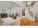 Bright and airy living room featuring an elegant staircase and beautiful hardwood floors at 1145 Wyndemere Cir, Longmont, CO 80504