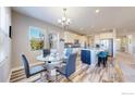 Cozy dining area adjacent to the kitchen featuring a modern chandelier and large windows at 11829 Deorio St, Parker, CO 80134